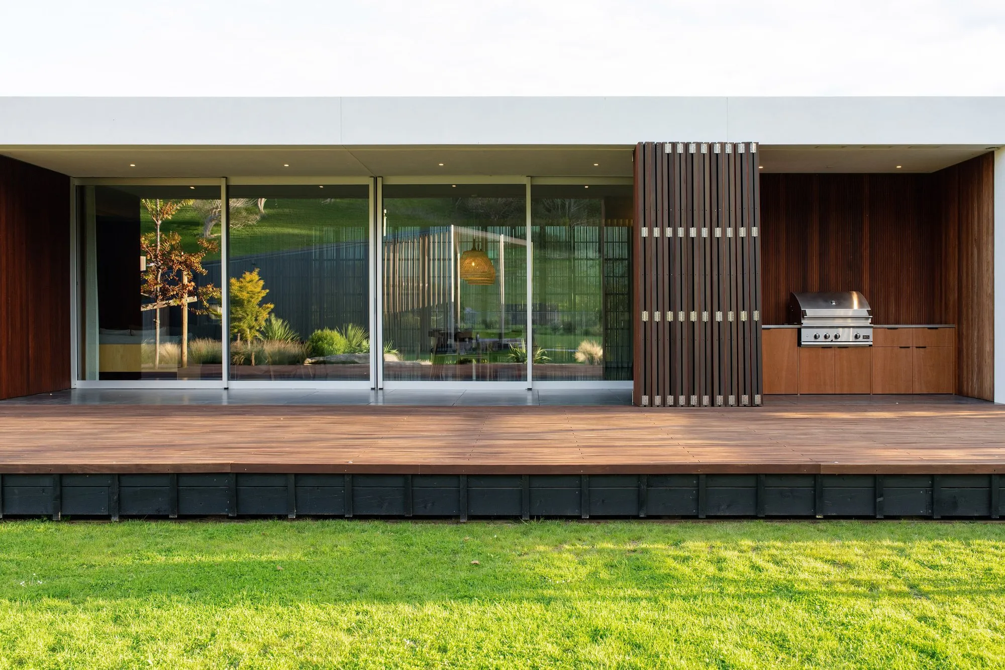 Timber deck and sliding glass doors along a single-level home
