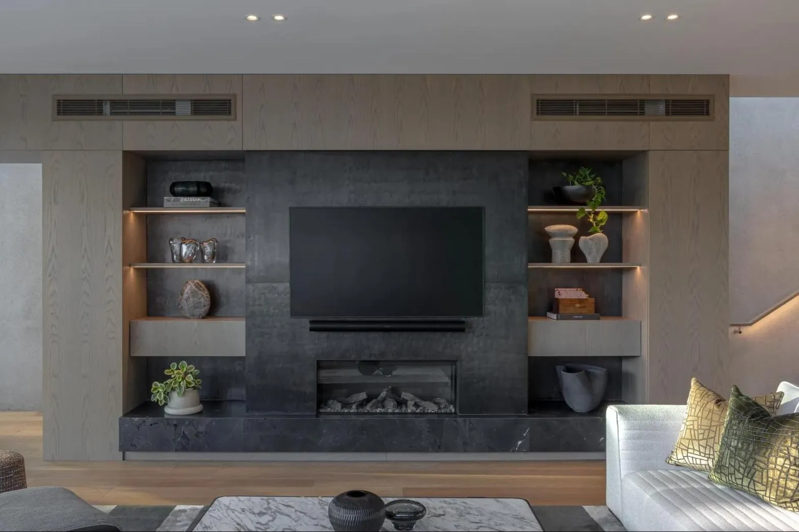 Fireplace wall with lit timber shelving